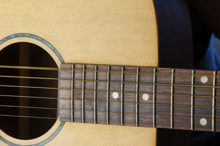 A trembling string on an acoustic guitar, motion blur. Vibration of the sixth string of a yellow...