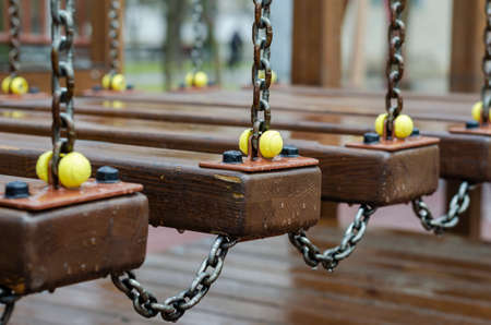 Empty children's playground after the rain. Wet swing among puddles. Weather, precipitation.の写真素材