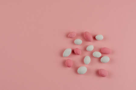 Sweet Dragee on a pink background. Peanuts covered with sugar glaze. White, pink. Top view, flat lay. Copy spaceの写真素材