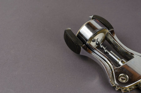 Old corkscrew on a gray background. Metallic Shiny Corkscrew. Side view at an angle. Selective focusの写真素材