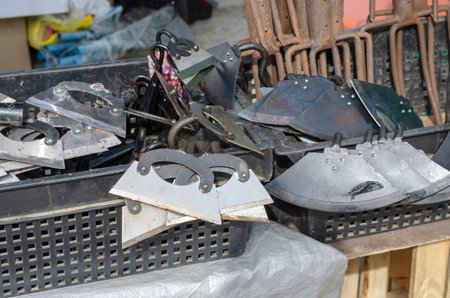 A counter with new metal garden tools. Garden hoes and Pitchfork in black plastic boxes. Spring...