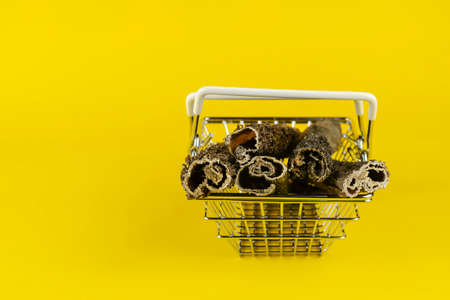 Shopping basket with dog treats on a yellow background. Natural dried chew treats for pets. Sticks of dried beef tripe. Pet Supplies.の写真素材