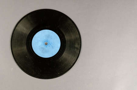 Old music record on a gray background. Dusty scratched vinyl record. Top view, flat lay. Copy spaceの写真素材