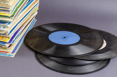 A collection of old comics, magazines, and vinyl records on a gray background. Lots of old shabby...