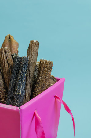 Box of treats on a blue background. Dried dental goodies for puppies, adult dogs and seniors dogs. Delicious Beef Sticks Stomach. Bovine tripe.Gift Box.の写真素材