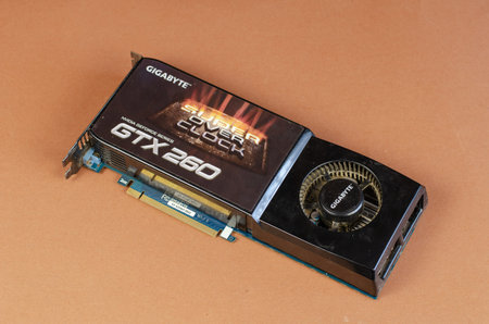 Graphics card brand Gigabyte NVidia GeForce on a brown background. Dusty computer components....