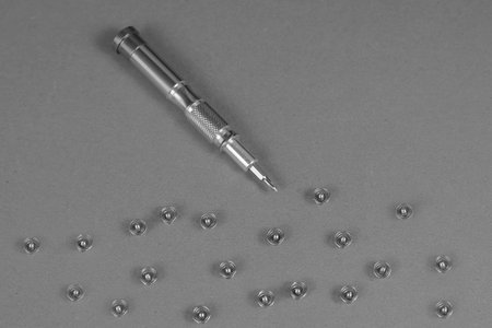Computer repair services and components concept. Screws and a screwdriver unscrewed from a computer....