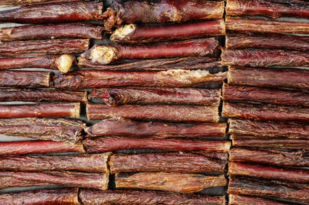 Dried dog treat sticks full frame. Dried beef esophagus horizontally. Natural chewy goodies for pets.の写真素材