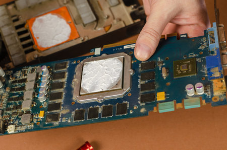 Computer repair services and components concept. A man is holding a disassembled computer graphics...