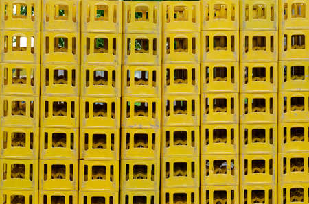 Yellow Stackable Plastic Bottle Boxes. Lots of empty used glass container crates. An industrial concept.の写真素材