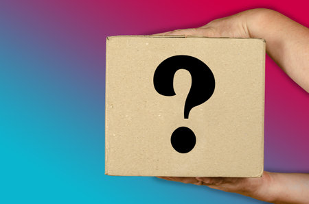 Hands holding cardboard box on colored gradient background. Man with a square package of recycled material. Question mark on the box. Side viewの写真素材