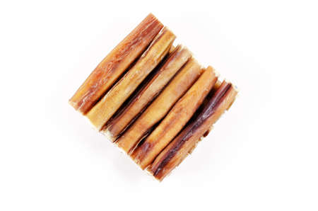 Natural chewy treats for dogs on a white background. Carefully stacked 5-inch bully sticks. Helpful treats for pets of all breeds and ages. Top view.の写真素材