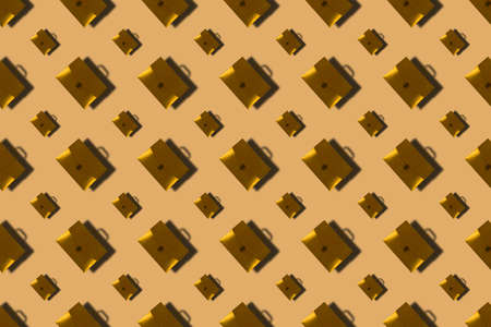 Gold briefcases for paper on brown background. Closed plastic repeating briefcases with handle. Stationery, office accessories, Business.の写真素材