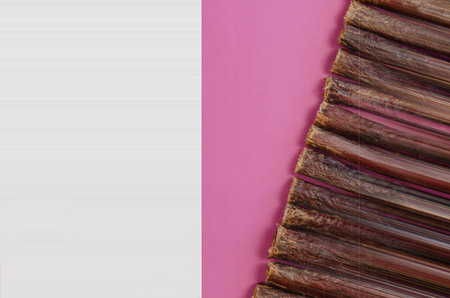 Sticks of dog treats and a blank white sheet on a pink background. Dried beef esophagus. Natural...
