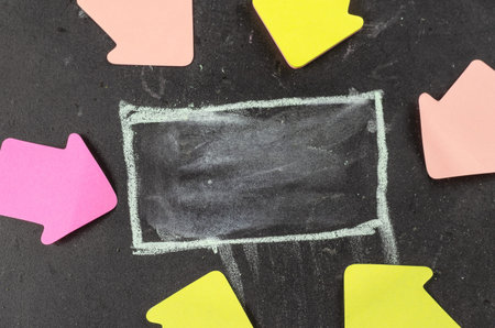 The hand-drawn white rectangle on the chalkboard and multicolored arrows. Paper arrows around the...