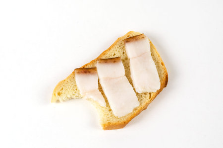 Sandwich bite on white background. Sandwich with salted lard. Three slices of pork fat with burnt...