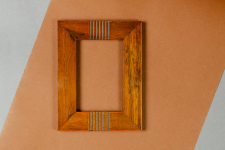 Brown wooden photo frame on brown background. Blank picture frame. Top view.