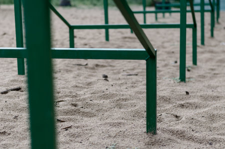 Close-up of a recurring green metal structure set in the sand in a receding perspective. Special...