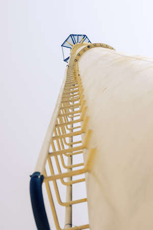 Defocused shot of a tall yellow metal tower with steps. Communication tower opposite the sky. View from below upward. Industry. Blurring, noise, grain effect.の写真素材