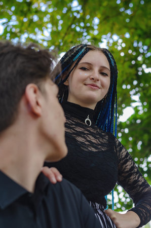 Man and woman flirting with each other in front of green leaves. A young heterosexual couple....
