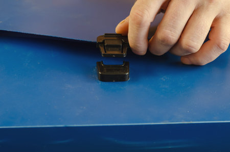 Adult male left hand opens briefcase for papers. Flexible briefcase with lock and handle. Close-up....