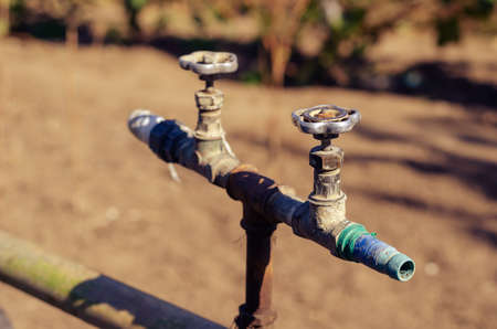 Old water taps against a blurry brown background. Two Taps horizontally. Outdoor. Selective focus.の写真素材