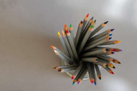 Multicolored Pencils in a glass top view. Gray watercolor pencils for drawing on paper. Creativity, hobbies. Selective Focus.の写真素材