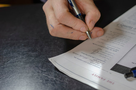Test. An adult male takes an English language test. A ballpoint pen hand writes the answers to the counter questions. Emigration, change of citizenship concept. Ukraine, Nikolaev - 10 21 2020のeditorial素材