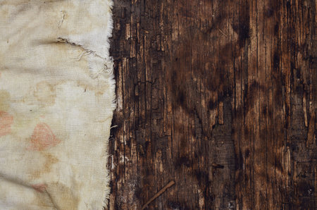 Torn rag on an old burnt wooden surface. Dirty cloth on the left side of the frame. Top view....