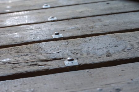Old numbered boards. Repeated floorboards with nailed aluminum tags. Close-up. Blur, noise, grain...