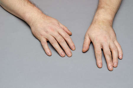 Two Hands of a middle-aged man against a gray background. indoors. selective focus.の写真素材