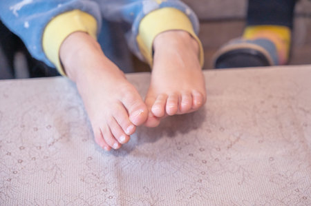 A close-up of my grandson's bare feet. Two feet with unevenly trimmed fingernails. A child in...