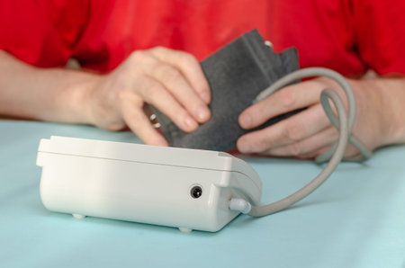 An adult male uses a digital blood pressure monitor. Cardiology. Sequence. Part 1. Inside the room....