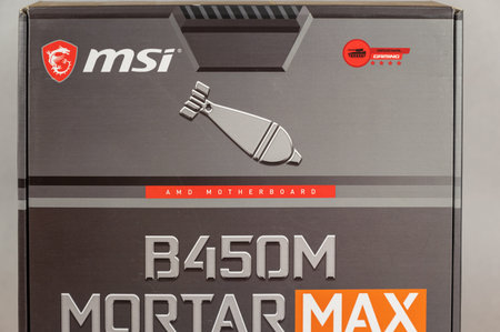 MSI B450 MORTAL MAX motherboard against a gray background. Black box with the new computer hardware....