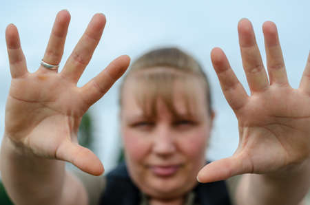 Defocused Portrait of an adult woman with her arms outstretched forward. Woman with open palms showing gesture of feet to camera.の写真素材