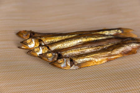 Smoked capelin against a beige background. Five ready-to-eat little fish. seafood.の写真素材