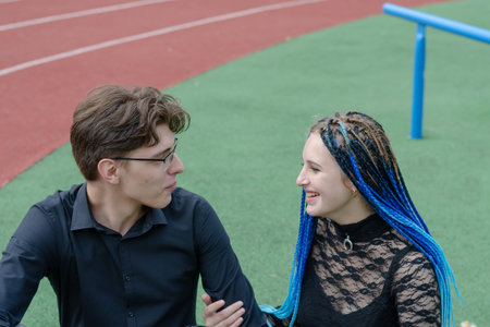 A happy young woman and a young man. Laughing heterosexual couple in love outside. Funny young...