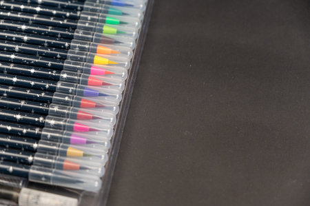 Set of watercolor markers in a pack against a black background. Multicolored markers for drawing on paper. Creativity, learning to draw concept.の写真素材