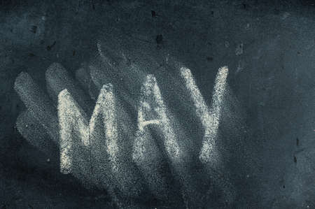 Semi-erased word MAY on black chalkboard. handwritten word. Fuzzy letters on black surface. The concept of alternation of the months of the year. Calendarの写真素材