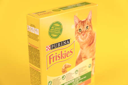 Purina Friskies cat food. Cardboard box with dry pelleted pet food. yellow background. selective focus. Ukraine, Mykolayiv - 05 25 2022のeditorial素材