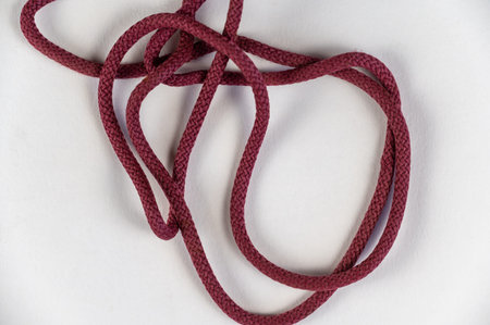 A tangled red rope against a neutral background. Round rope without knots. close-up. selective...