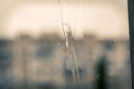 A jet of water on a dirty window pane. Blurred and unfocused background. selective focus.の写真素材