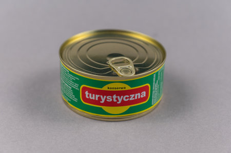 Canned pork against a gray background. Pork stew of the Polish brand Sokolow. The inscription in Polish means TOURISTIC. Ukraine, Mykolaiv - 06 23 2022.のeditorial素材