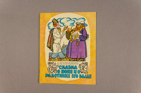 Russian folk tale About the Priest and His Worker Balda in Pushkin's interpretation. An old book against a gray background. Ukraine, Mykolaiv - 06 23 2022のeditorial素材