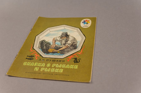 Russian folk tale About the Fisherman and the Fish. A fairy tale by the famous Russian writer and poet Alexander Pushkin. An old book against a gray background. Ukraine, Mykolaiv - 06 23 2022のeditorial素材