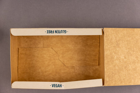Empty brown paper box. Gluten free. Vegan. Inscription on the end of the cardboard box. Healthy Food...