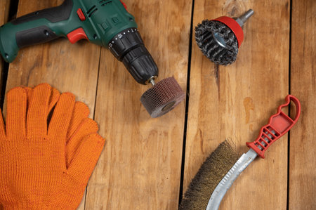 Electric drill, flap wheel, knot bowl wire disk, metal brush against the wooden background. Electric and hand tools for woodworking. indoors. selective focus.の写真素材