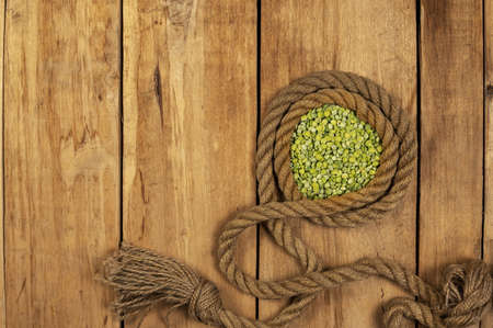 Dry split peas. green beans. ship rope. Rough boards. wooden background. Health food. view from above. Copy space for text and design elements.の写真素材