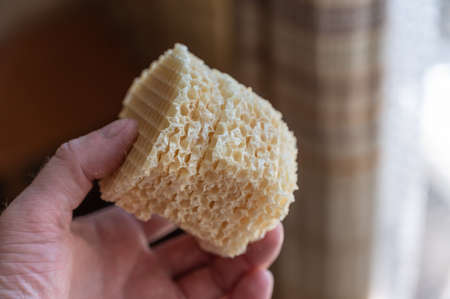 Male holding prepared waffle crusts in his hand. Stack of crispy hexagonal crusts to be stuffed with ground meat and other fillings. home cooking. selective focus.の写真素材