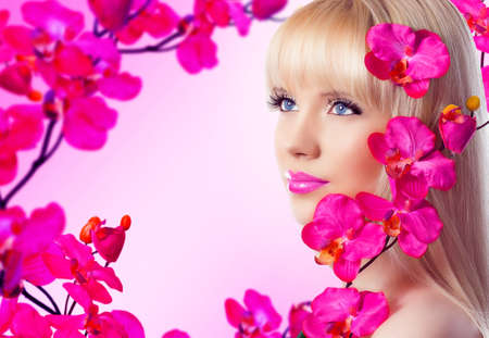 Beautiful blonde young woman with flowersの写真素材